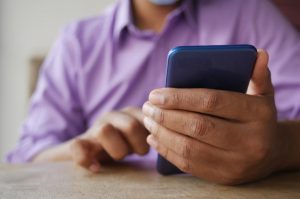 Uomo in camicia che utilizza lo smartphone